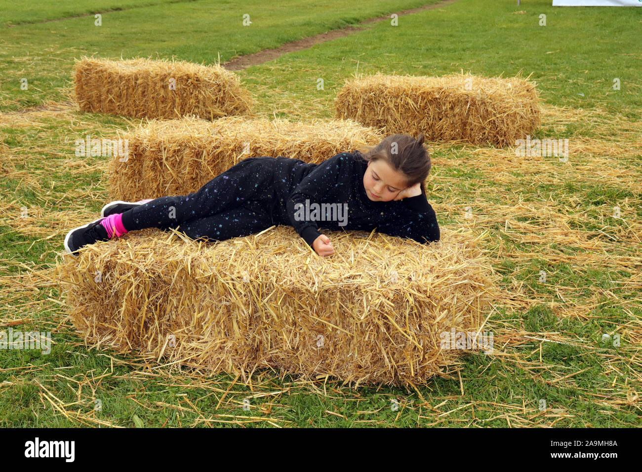 Girl lying on Hay Bale Stock Photo