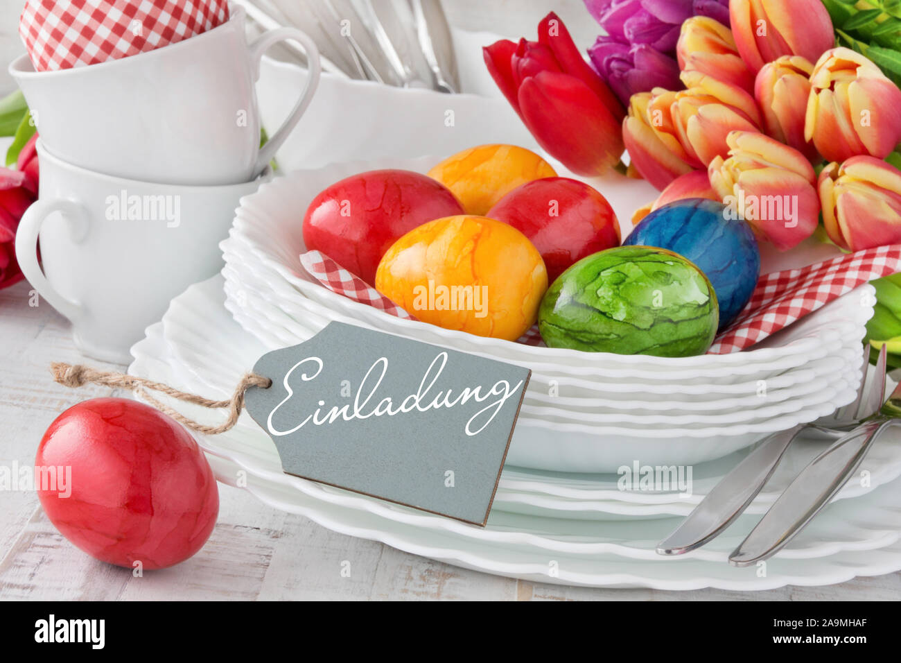 German Invitation Easter Decoration Breakfast Table Red Tulips with red Easter Eggs as Background Stock Photo