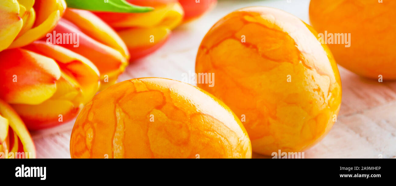 Yellow Easter eggs with tulips on white background Stock Photo - Alamy
