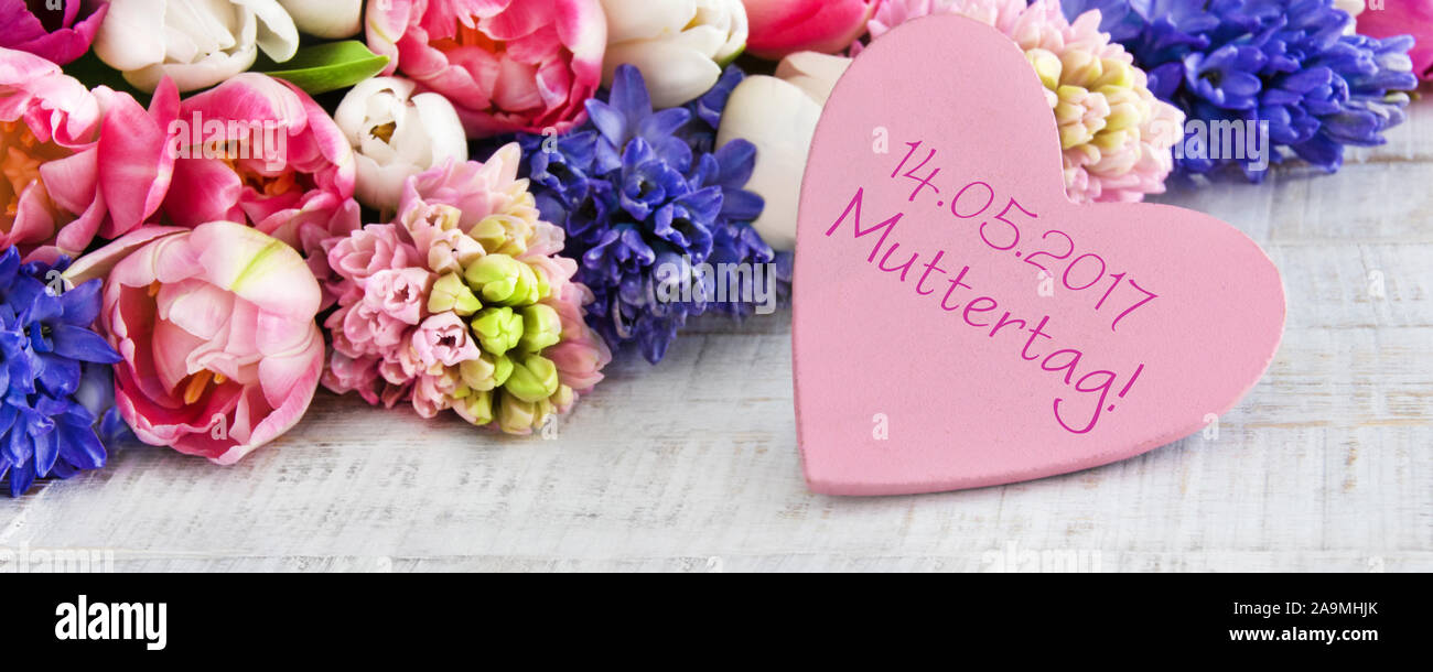 German Mother's Day flowers and heart on wood as background Stock ...