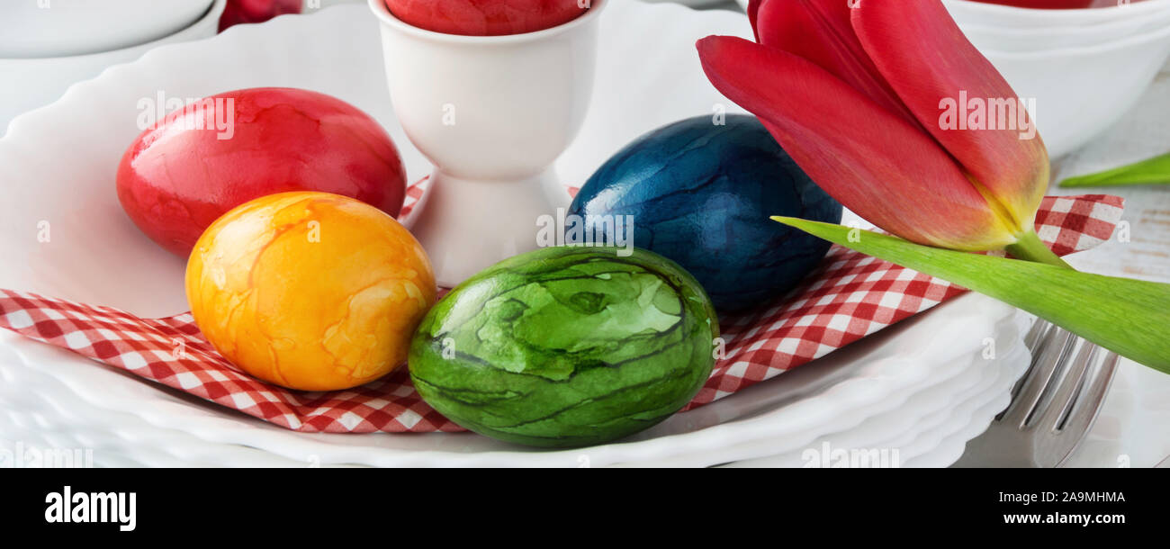 Easter Decoration Breakfast Table Red Tulips with red Easter Eggs as Background Stock Photo