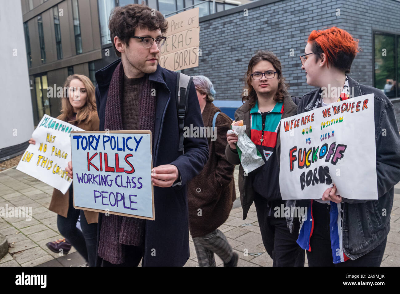 London, UK. 16th November 2019. A man holds a poster 'Tory Policy Kills WOrking Class People'. Protesters from FCKBoris at Brunel University in Uxbridge  urge everyone to register and vote against Boris Johnson and kick him out for his racist, elitist politics.  Johnson had a majority of just over 5 thousand in 2017 and Labour candidate Ali Milani has strong hopes of beating him and the other 10 candidates. Peter Marshall/Alamy Live News Stock Photo