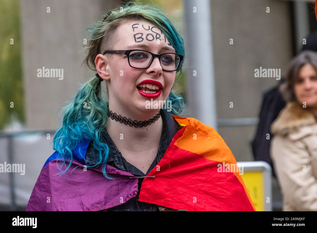 London, UK. 16th November 2019. A protester in a rainbow flag with a message for Boris on her forehead as protesters from FCKBoris at Brunel University in Uxbridge  urging everyone to register and vote against Boris Johnson and kick him out for his racist, elitist politics.  Johnson had a majority of just over 5 thousand in 2017 and Labour candidate Ali Milani has strong hopes of beating him and the other 10 candidates. Peter Marshall/Alamy Live News Stock Photo