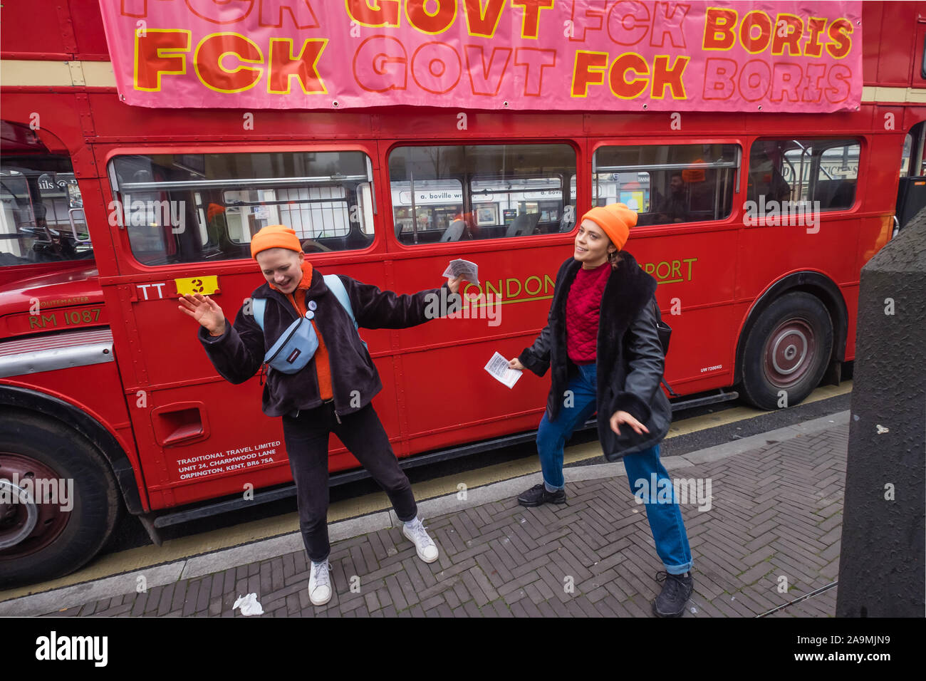 London, UK. 16th November 2019. People dance to music from the bus. Protesters from FCKBoris in orange knitted hats walk through Uxbridge shopping centre handing out fliers urging everyone to register and vote against Boris Johnson and kick him out for his racist, elitist politics. They marched with a sound system on a bus to Brunel University to persuade students. Johnson had a majority of just over 5 thousand in 2017 and Labour candidate Ali Milani has strong hopes of beating him and the other 10 candidates. Peter Marshall/Alamy Live News Stock Photo