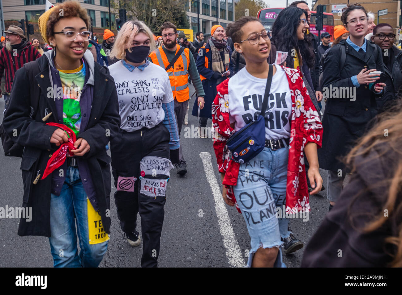 London, UK. 16th November 2019. Protesters from FCKBoris in orange knitted hats walk through Uxbridge  urging everyone to register and vote against Boris Johnson and kick him out for his racist, elitist politics. They marched with a sound system on a bus to Brunel University to persuade students. Johnson had a majority of just over 5 thousand in 2017 and Labour candidate Ali Milani has strong hopes of beating him and the other 10 candidates. Peter Marshall/Alamy Live News Stock Photo