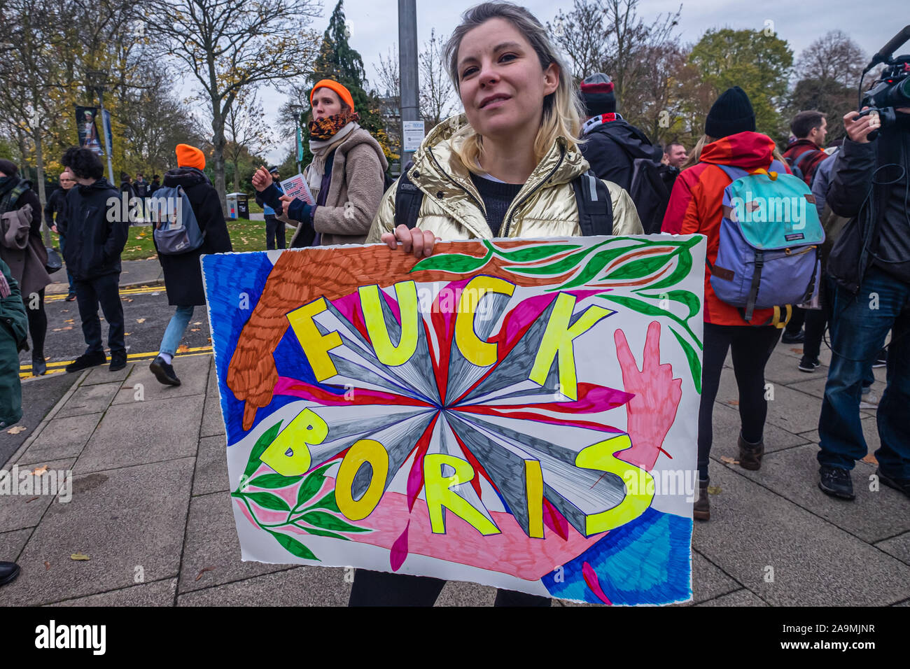 London, UK. 16th November 2019. A woman holds a hand painted poster. Protesters from FCKBoris arrive at Brunel University in Uxbridge  urging everyone to register and vote against Boris Johnson and kick him out for his racist, elitist politics.  Johnson had a majority of just over 5 thousand in 2017 and Labour candidate Ali Milani has strong hopes of beating him and the other 10 candidates. Peter Marshall/Alamy Live News Stock Photo