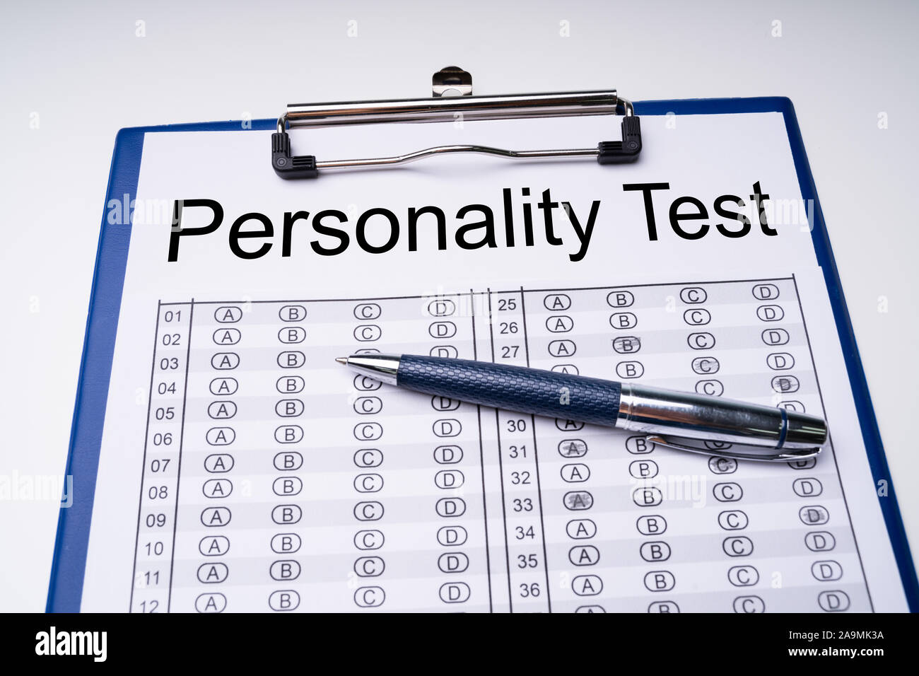 High Angle View Of Personality Test Sheet And Pen On Clipboard Over White Table Stock Photo