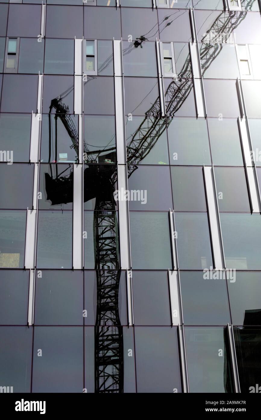 WA17326-00...WASHINGTON - Construction crane reflected on a glass building in Seattle. Stock Photo