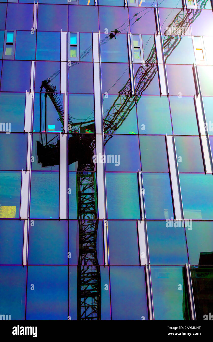 WA17327-00...WASHINGTON - Construction crane reflected on a glass building in Seattle. Stock Photo
