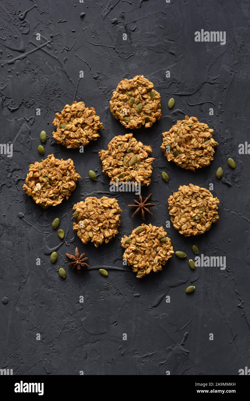 Healthy vegan gluten free sweets concept. Breakfast oatmeal cookies with pumpkin seeds on black background top view copy space Stock Photo