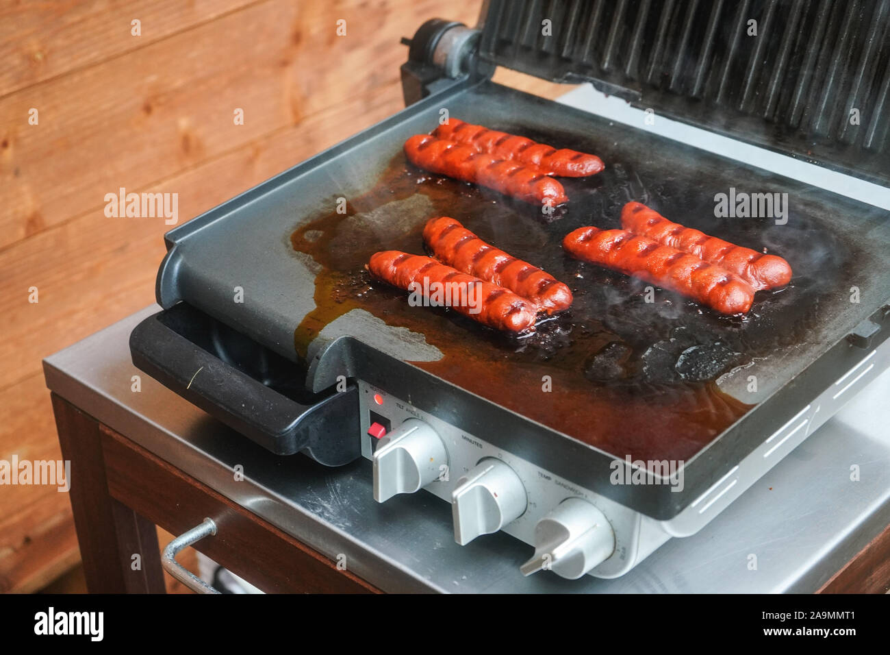 Small bratwurst hot dog frankfurter sausages grilled on electric grill