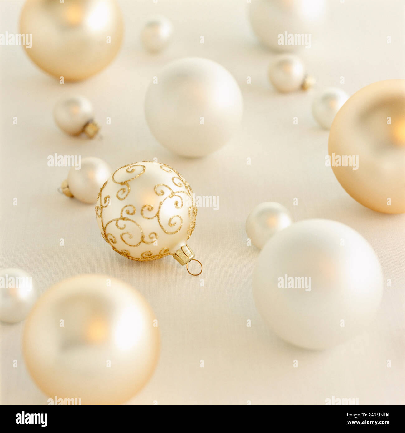 Close-up closeup of beautiful, fancy, elegant, silver, white and gold Christmas ornaments on white background. Luxury holiday decorations backgrounds. Stock Photo