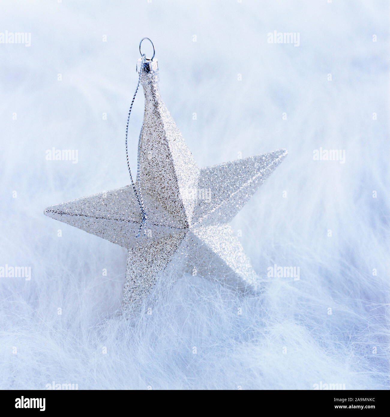Close-up closeup of simple, modern, silver glitter star Christmas ornament decoration on white background Stock Photo