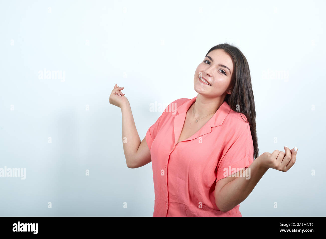 Young woman on white wall enjoy dancing while listening to music at a party Stock Photo