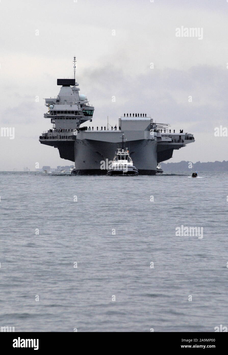 AJAXNETPHOTO. 16TH AUGUST, 2017. PORTSMOUTH, ENGLAND. - ROYAL NAVY'S BIGGEST WARSHIP SAILS INTO HOME PORT - HMS QUEEN ELIZABTH, THE FIRST OF TWO 65,000 TONNE, 900 FT LONG, STATE-OF-THE-ART AIRCRAFT CARRIERS SAILED INTO PORTSMOUTH NAVAL BASE IN THE EARLY HOURS OF THIS MORNING, GENTLY PUSHED AND SHOVED BY SIX TUGS INTO HER NEW BERTH ON PRINCESS ROYAL JETTY. THE £3BN CARRIER, THE LARGEST WARSHIP EVER BUILT FOR THE ROYAL NAVY, ARRIVED AT ARRIVED AT HER HOME PORT TWO DAYS AHEAD OF HER ORIGINAL SCHEDULE.  PHOTO: JONATHAN EASTLAND/AJAX  REF: D171608_6771 Stock Photo