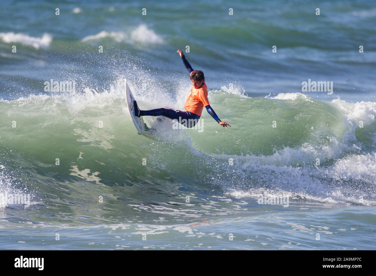 Surfer wearing Orange Shirt Cut Back Stock Photo