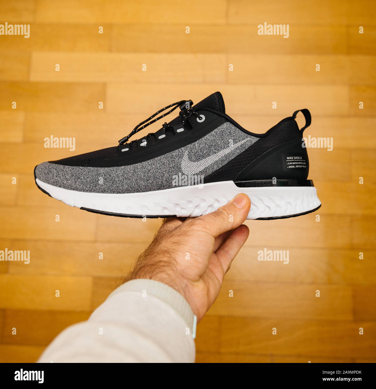 Paris, France - Oct 18, 2019: Square image POV man hand holding against  wooden floor gym background new sport waterproof and windproof running shoe  Nike Odyssey React Shield 2 Stock Photo - Alamy