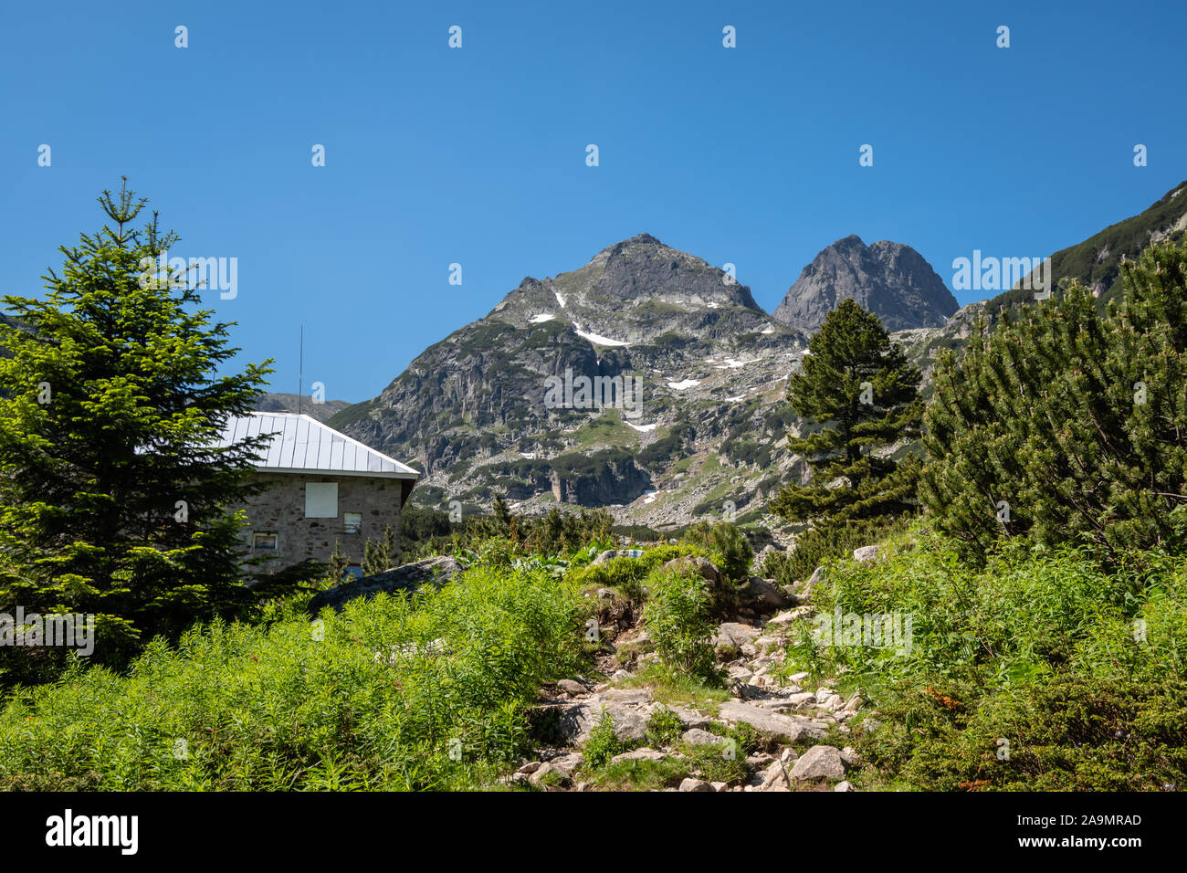 Malyovitsa hut and Malyovitsa peak in the Rila mountain during a sunny summer day and clear blue sky, Rila National Park, Bulgaria. Stock Photo