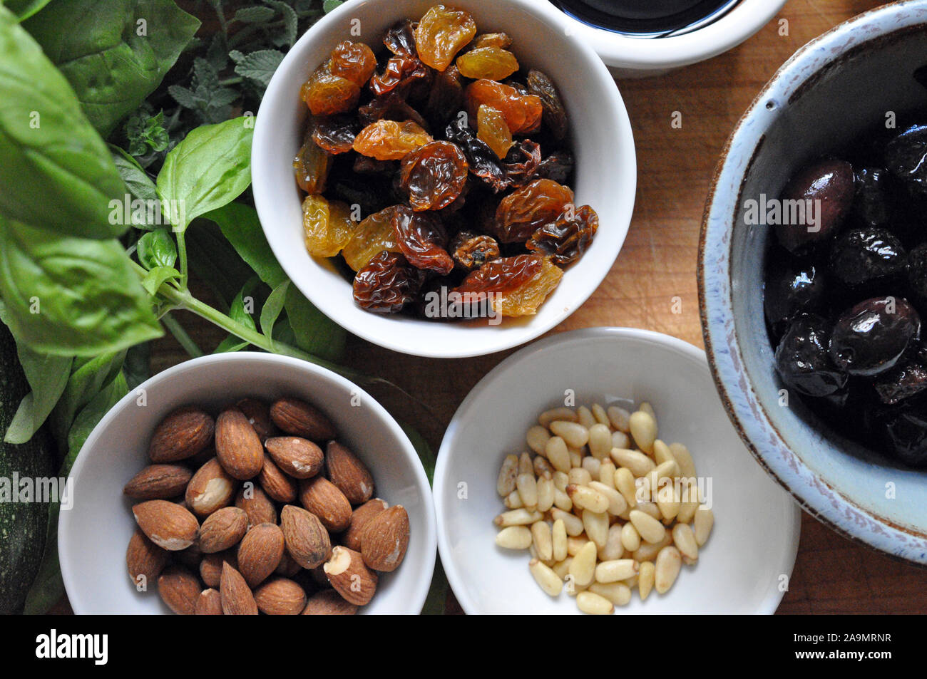 Herbs, Raisins, Nuts, Olives from above in small ceramic bowls Stock Photo