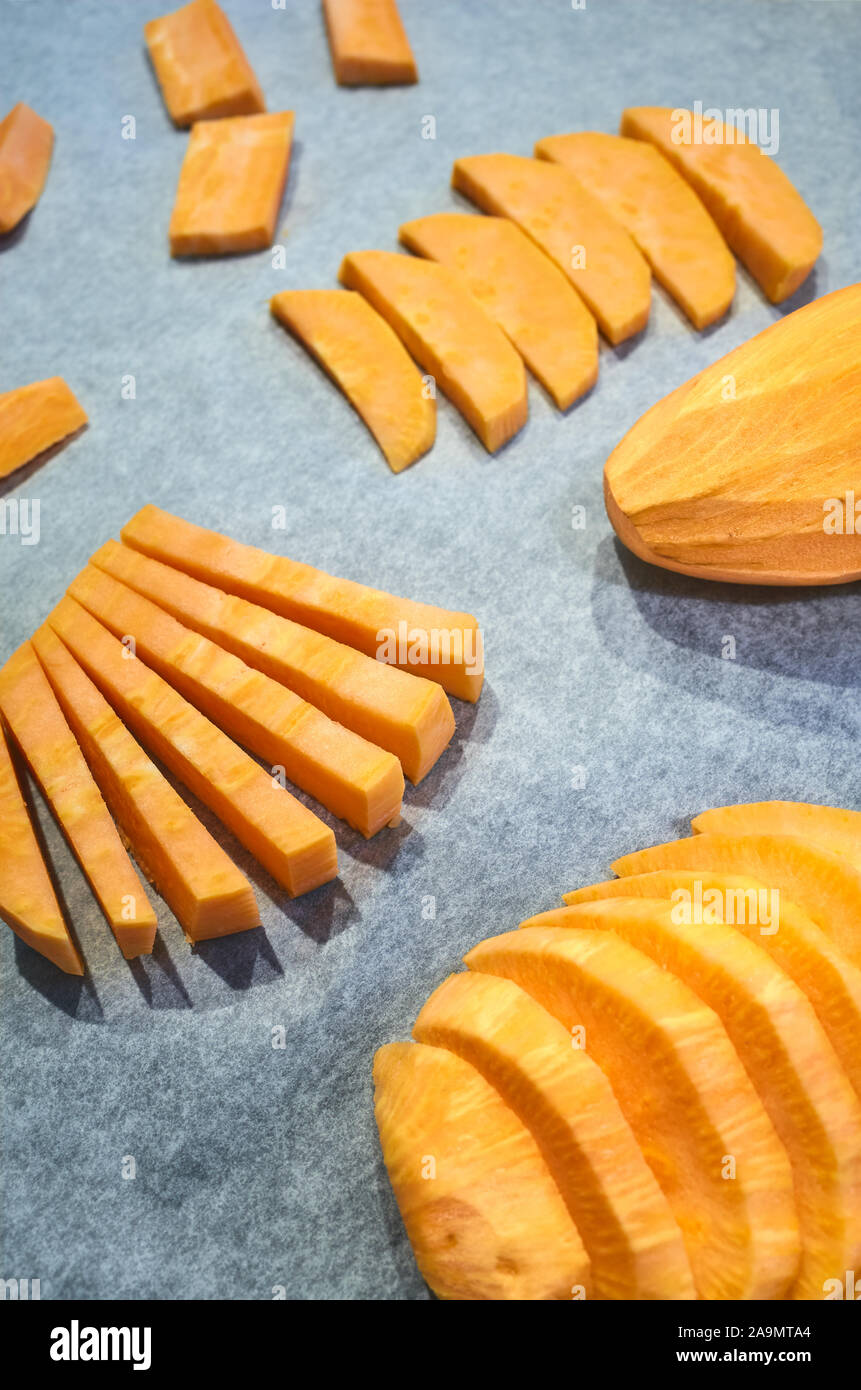 Fresh sweet potatoes on baking paper, selective focus. Stock Photo