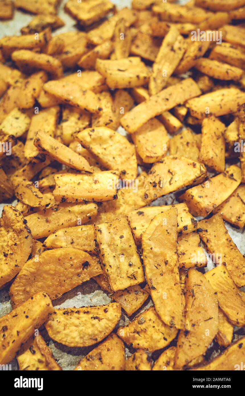 Roasted sweet potatoes with herbs, selective focus. Stock Photo