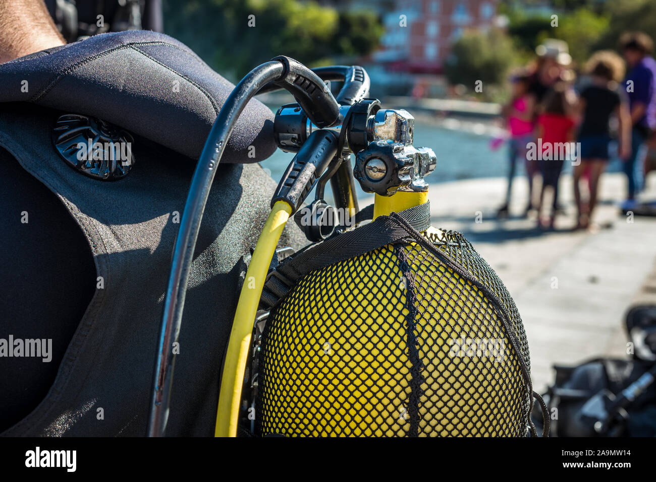Scuba diver getting ready for scuba diving on the beach. Setting up scuba gear and equipment - steel tank or cylinder, BCD, regulators and getting dre Stock Photo