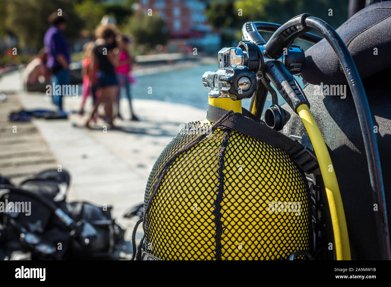 Scuba diver getting ready for scuba diving on the beach. Setting up scuba gear and equipment - steel tank or cylinder, BCD, regulators and getting dre Stock Photo