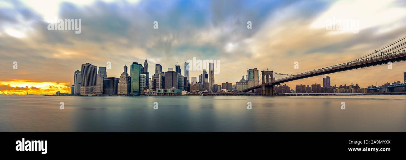 Manhattan skyline from Brooklyn with smooth water and moving clouds