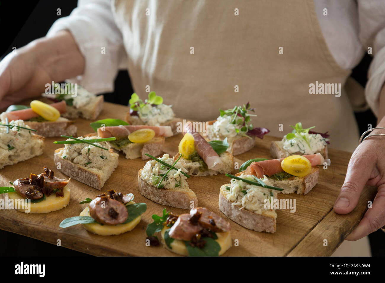 Italian Cicchetti or bacari on wooden tray, Venician-style tapas served at wine bars Stock Photo