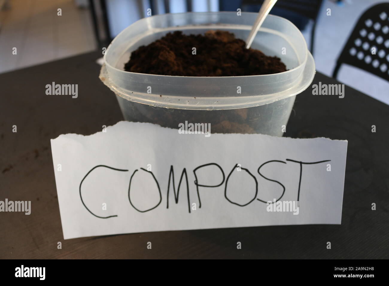 Photo of a container of used coffee grounds with a sign that says compost Stock Photo Alamy
