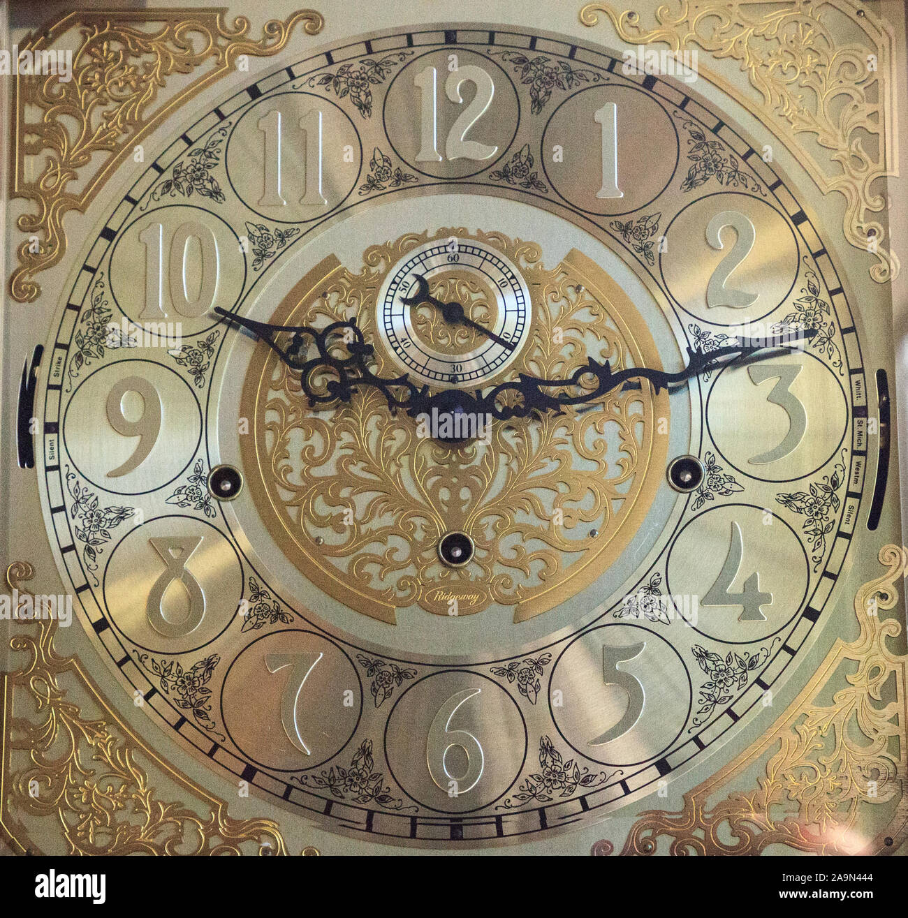 Old fashioned ornate grandfather clock at 1013 with a gold brass face