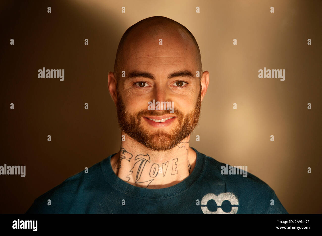 Middle aged man with a neck tattoo and beard portrait. Stock Photo