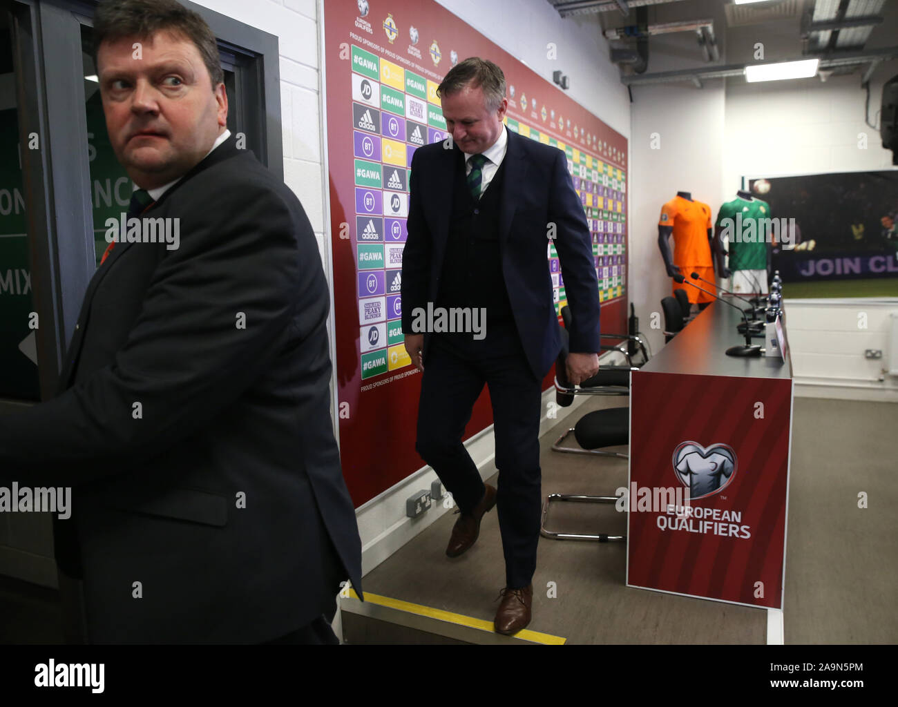 Northern Ireland Media Relations manager Nigel Tilson leads Ireland manager Michael O'Neill out during the UEFA Euro 2020 Qualifying match at Windsor Park, Belfast. Stock Photo