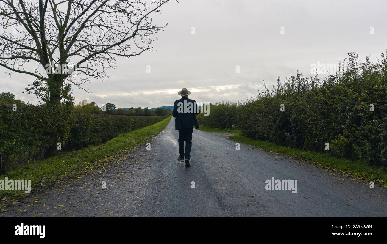 Man walking down country lane hi-res stock photography and images - Alamy