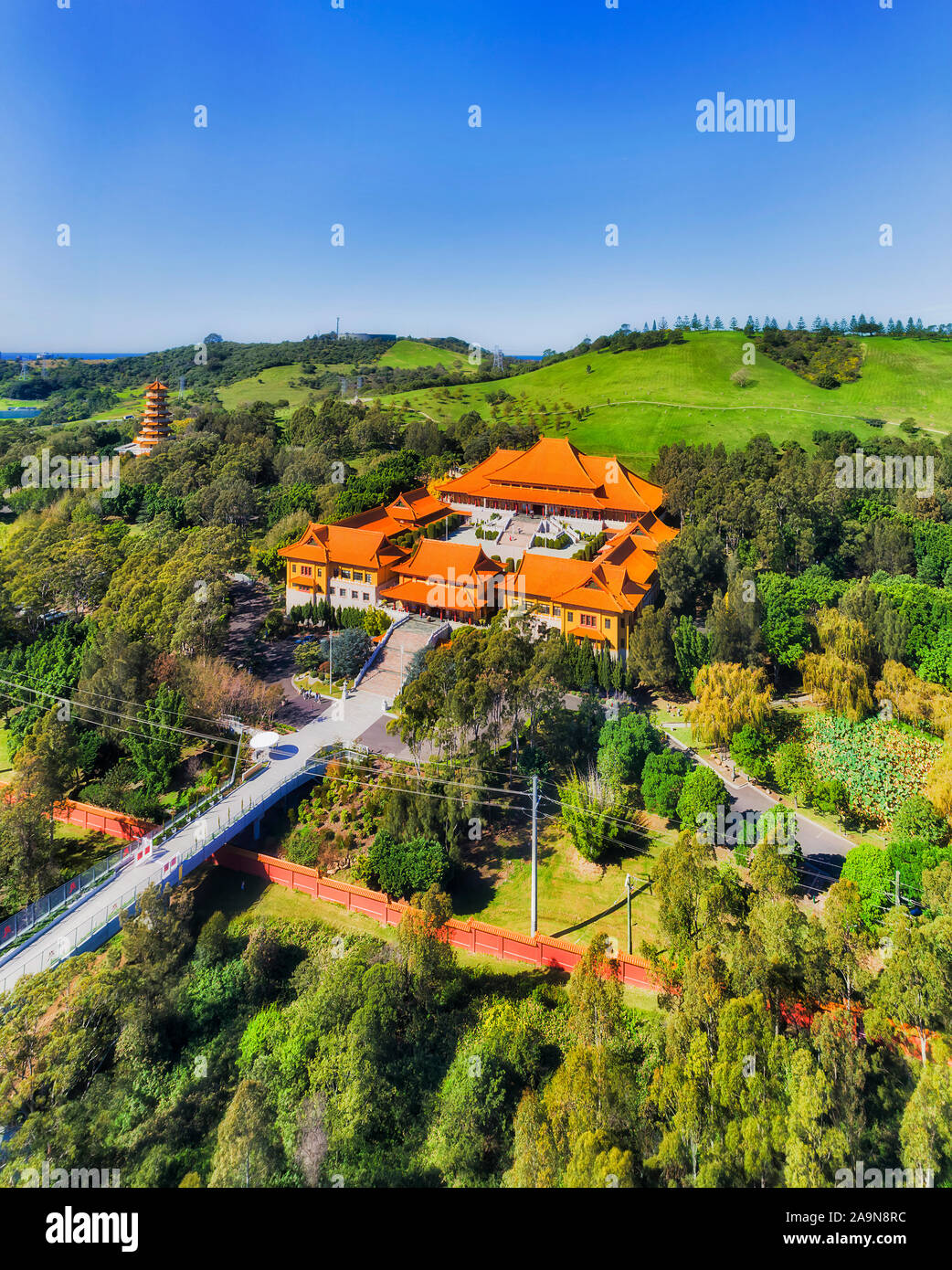 Australian asian Buddhism temple Nantien on green hillside near Wollongong city on Pacific Coast surrounded by green public park with tall Pagoda towe Stock Photo