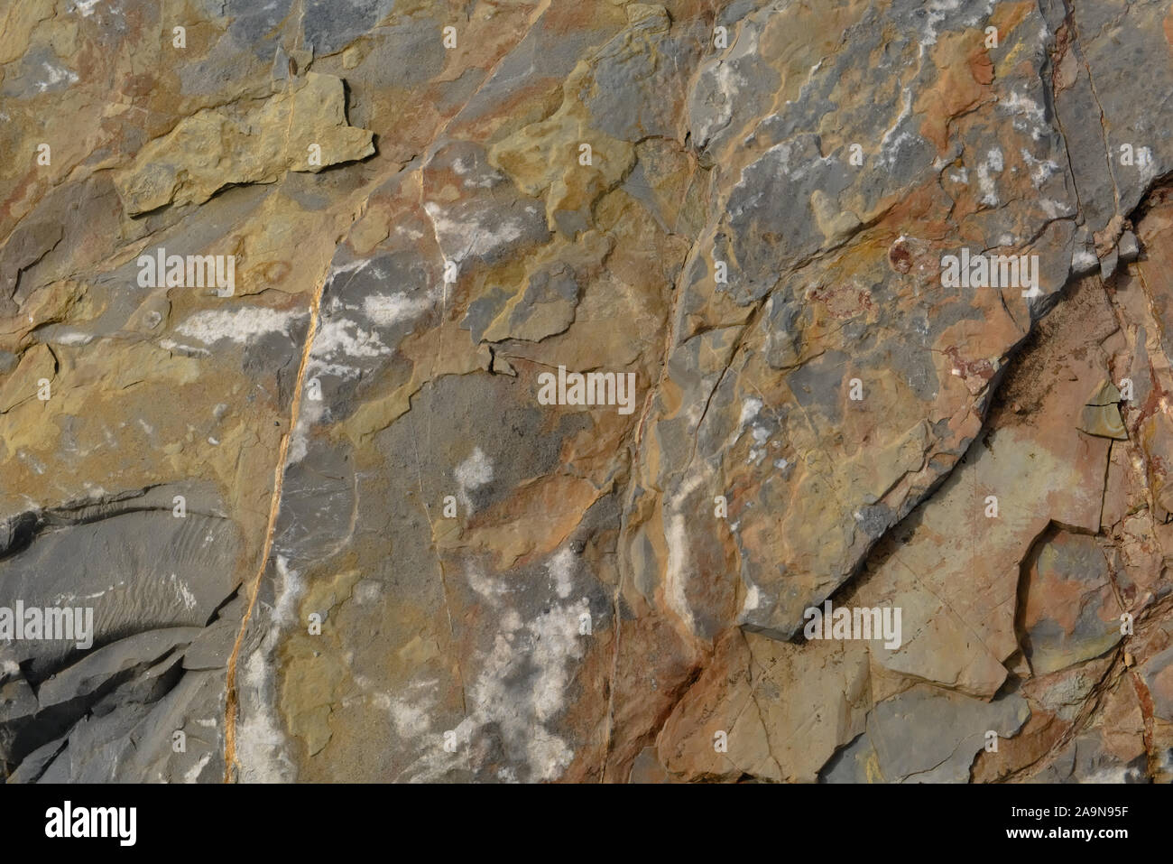 Multicolored natural stone texture background with shades of orange, yellow, grey and white Stock Photo