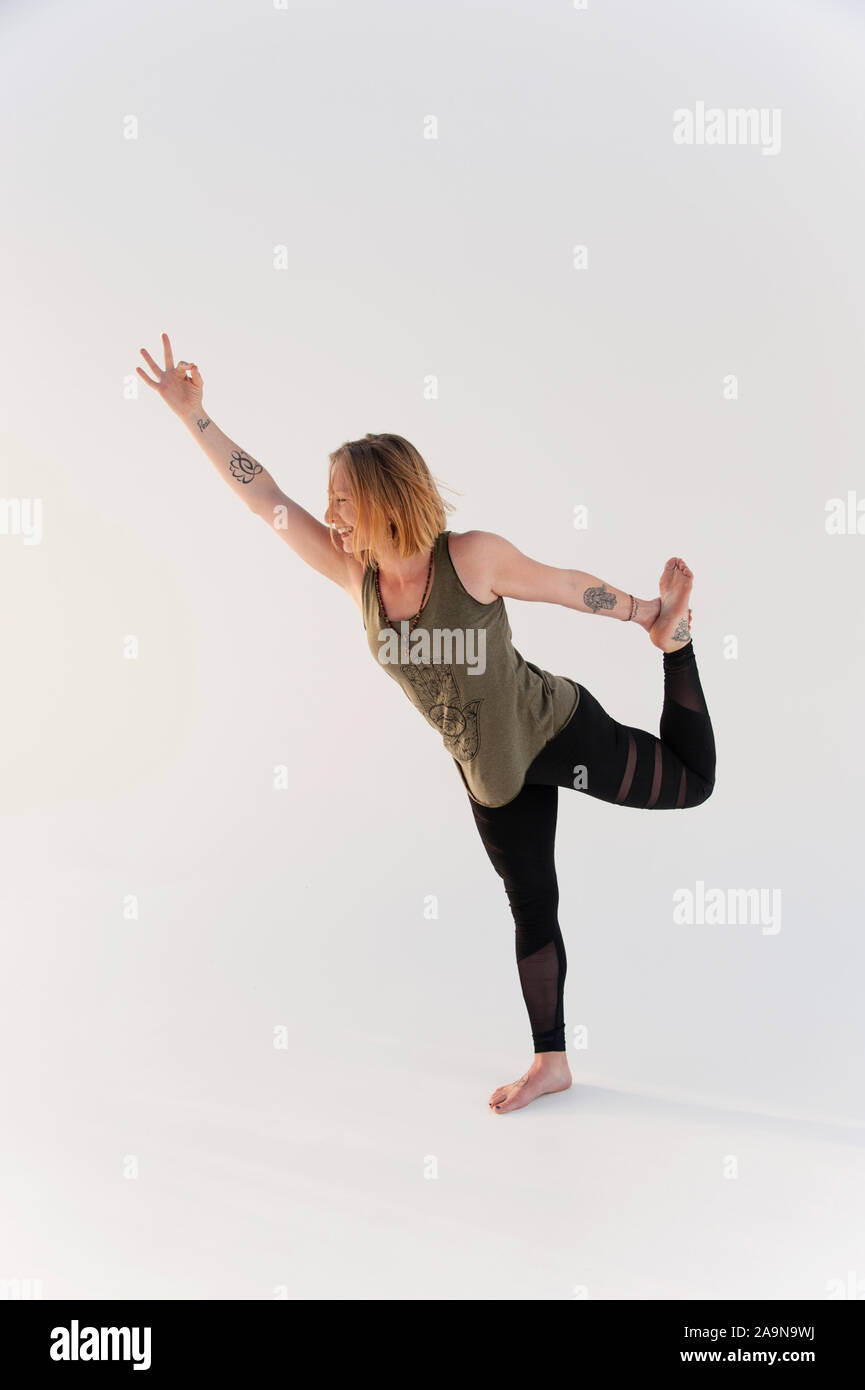 Woman practicing yoga asana on a white background. Stock Photo