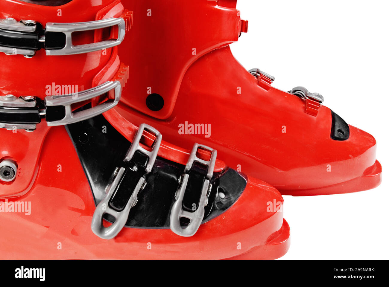 Two new red snow ski boots with plenty of buckles on an isolated white