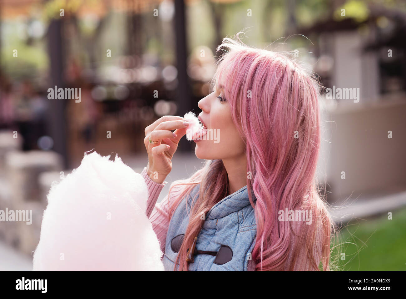 Adorable young woman with long pink hair eats and poses with sugar pink candy cotton. Concept happy times. Carefree girl. Good mood Stock Photo - Alamy Adorable young woman with long pink hair eats and poses with sugar pink candy cotton. Concept happy times. Carefree girl. Good mood Stock Photo - Alamy