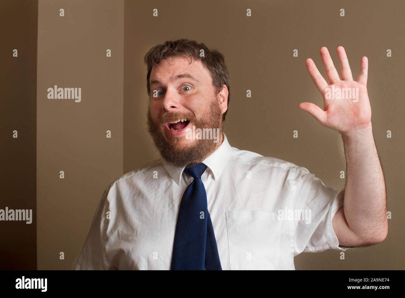 man with a big fake smile waiving at something Stock Photo