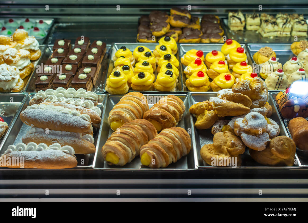 Italian pastry shop. Showcase on pastry shop. Cream and sweets. Stock Photo