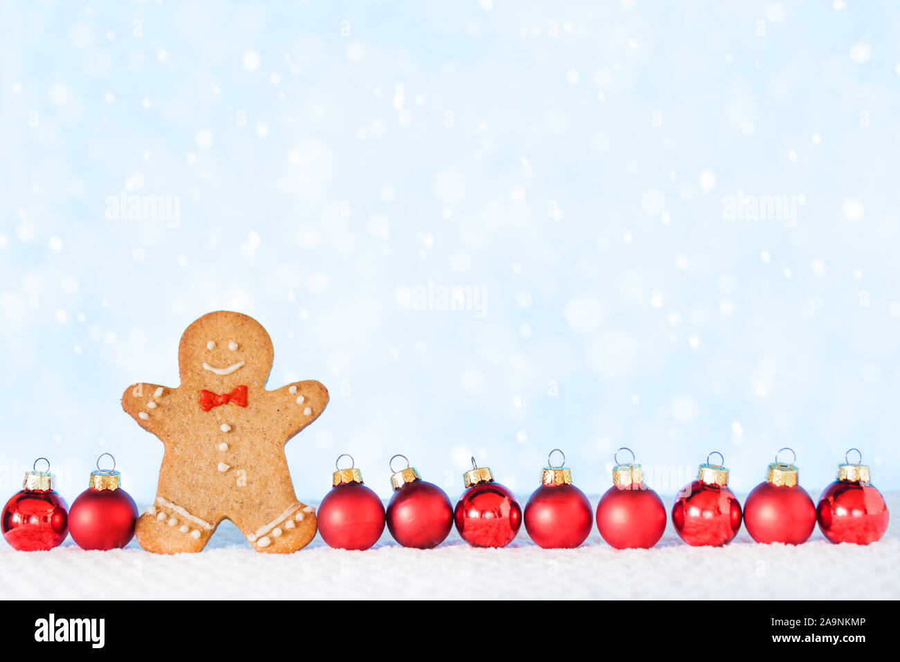 Christmas composition with Gingerbread man on white background. Trendy Christmas minimal concept - homemade gingerbread man and red ornaments, copy sp Stock Photo