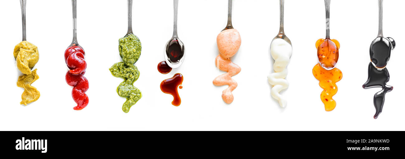 Sauces Assortment. Set of various sauces on spoons. Popular sauces isolated on white, top view, copy space. Homemade sauces set. Stock Photo