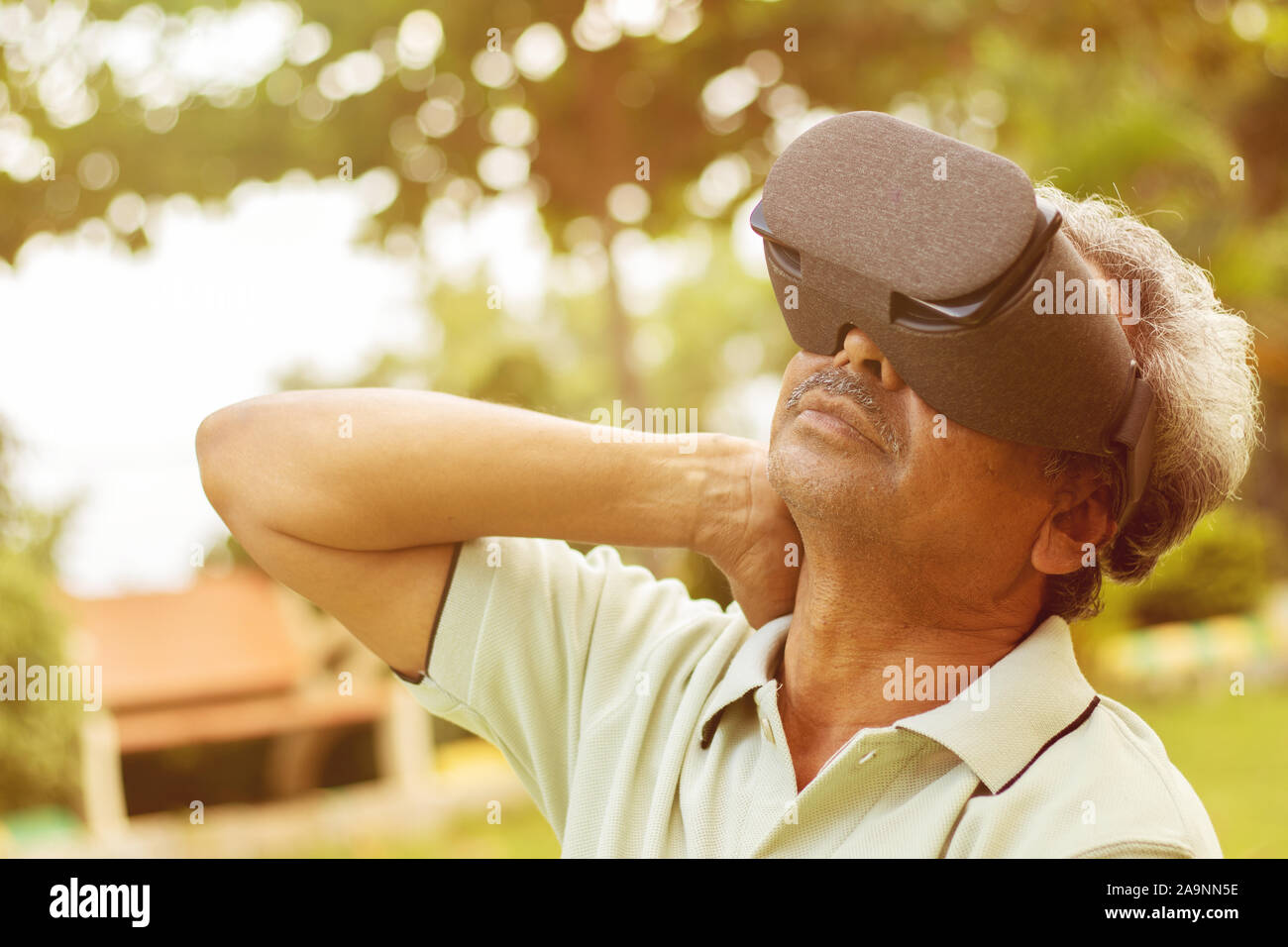 Senior man using VR google glass for exercise, Outdoor - Fitness concept using New technologies by elderly people - Old men stretching hands by Stock Photo