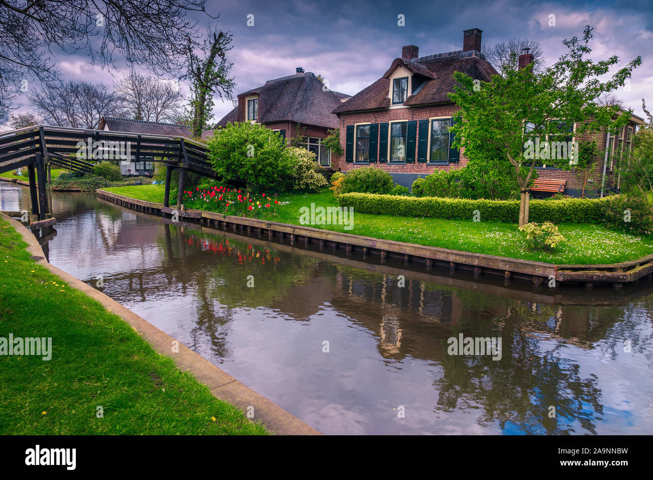 Fabulous touristic village with narrow water canals. Cute thatched houses with ornamental gardens in Giethoorn village, Netherlands, Europe Stock Photo