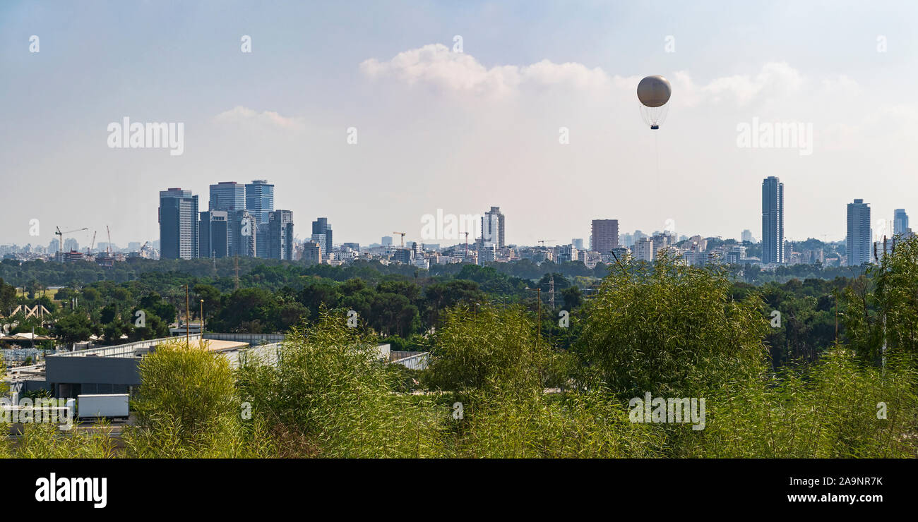 tel aviv city skyline from the university campus with yarkon park and ayalon highway in the middle ground and a hot air balloon in the sky Stock Photo