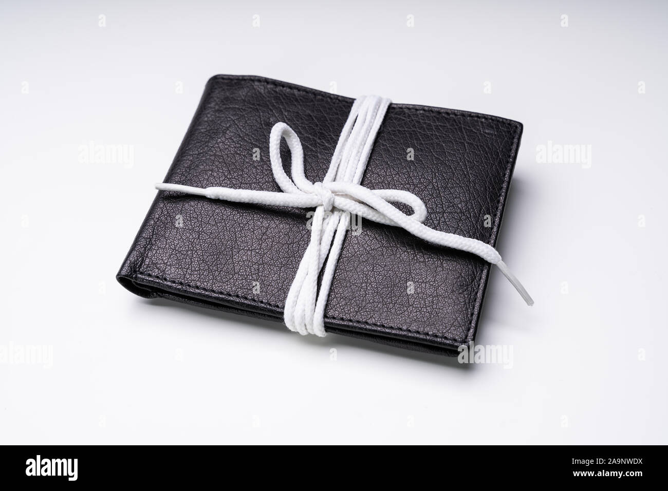 Elevated View Of Black Leather Wallet Tied With White Lace Isolated On White Backdrop Stock Photo