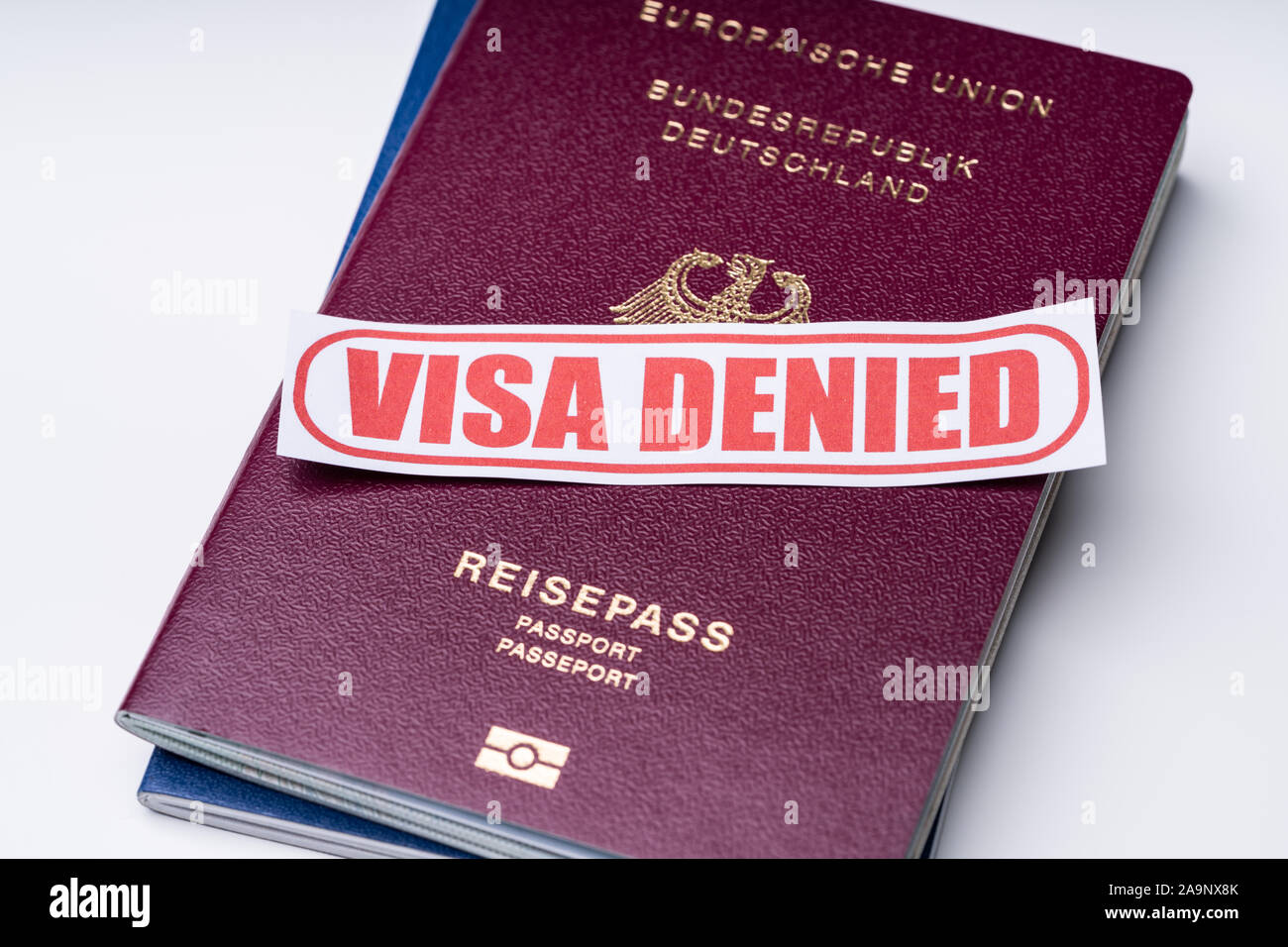 High Angle View Of Visa Denied Text On Notepaper With Passports Over White Backdrop Stock Photo