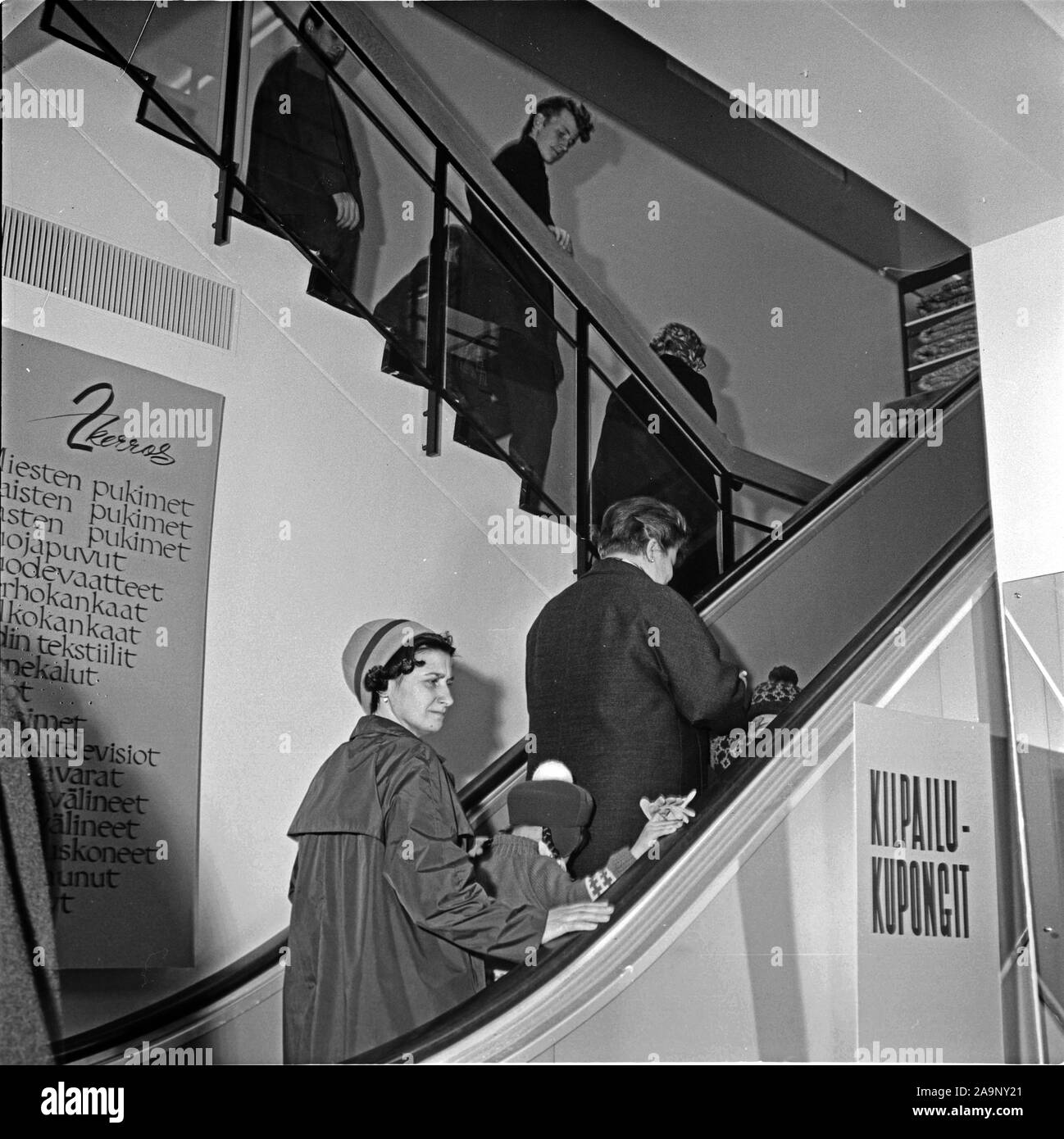 Finland History - Customers trying out an escalator at the opening of a Centrum department store run by Koitto cooperative. ca. 1960s Stock Photo