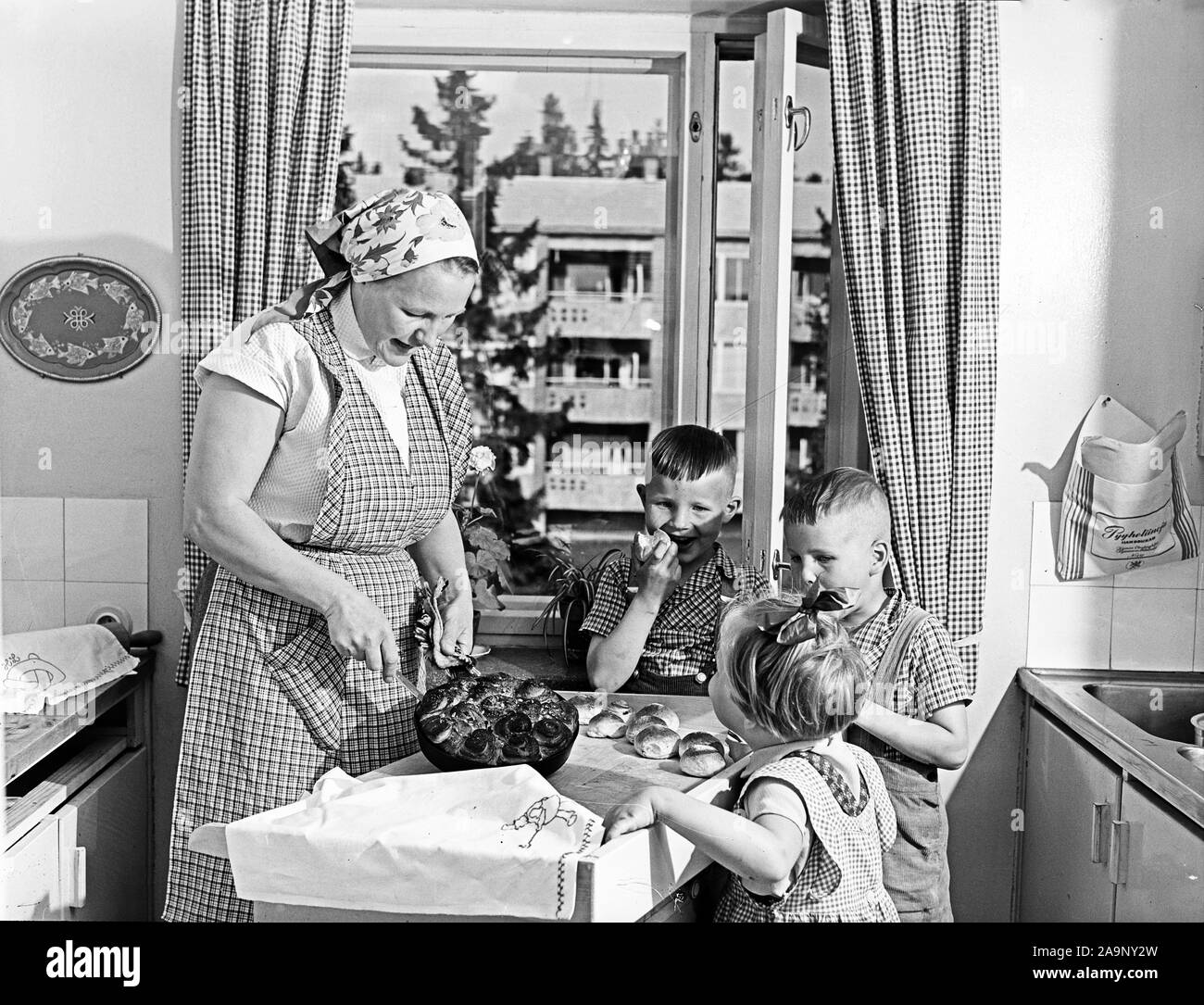 Finland History -  Mom bakes children's buns in the kitchen  ca. 1950s Stock Photo